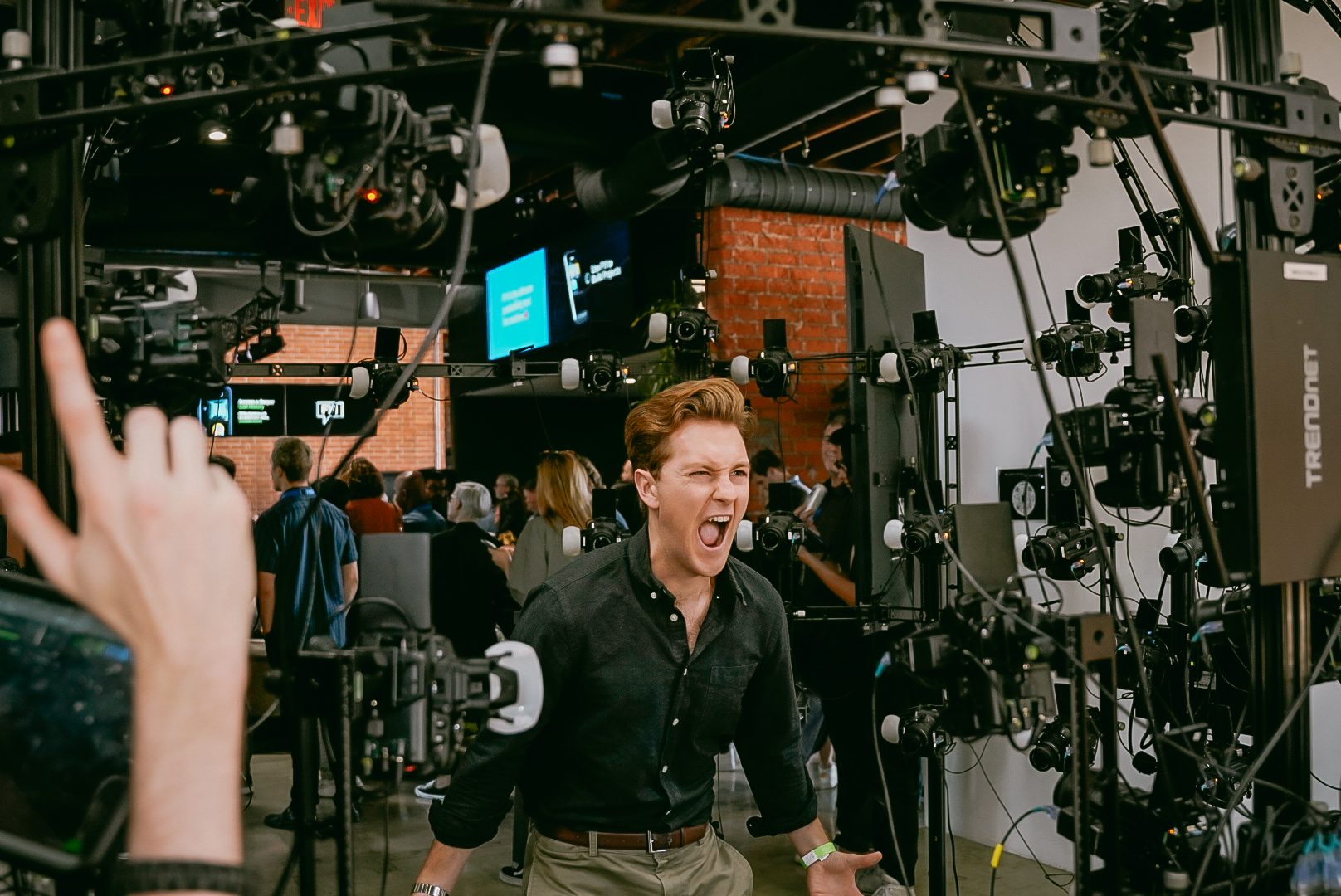 Quinn Halleck laughs in front of a rig of dozens of cameras during an interactive demo.