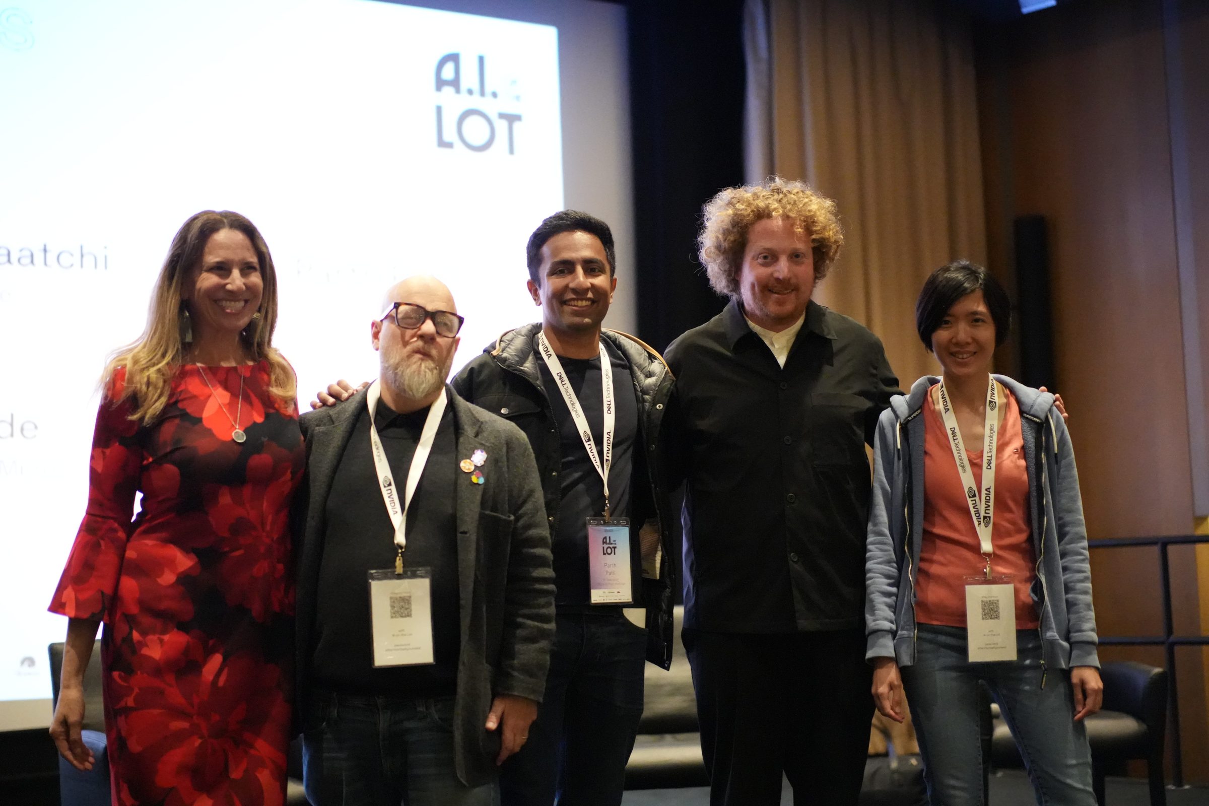 Panelists pose arm in arm under an AI on the Lot sign, name badges on.