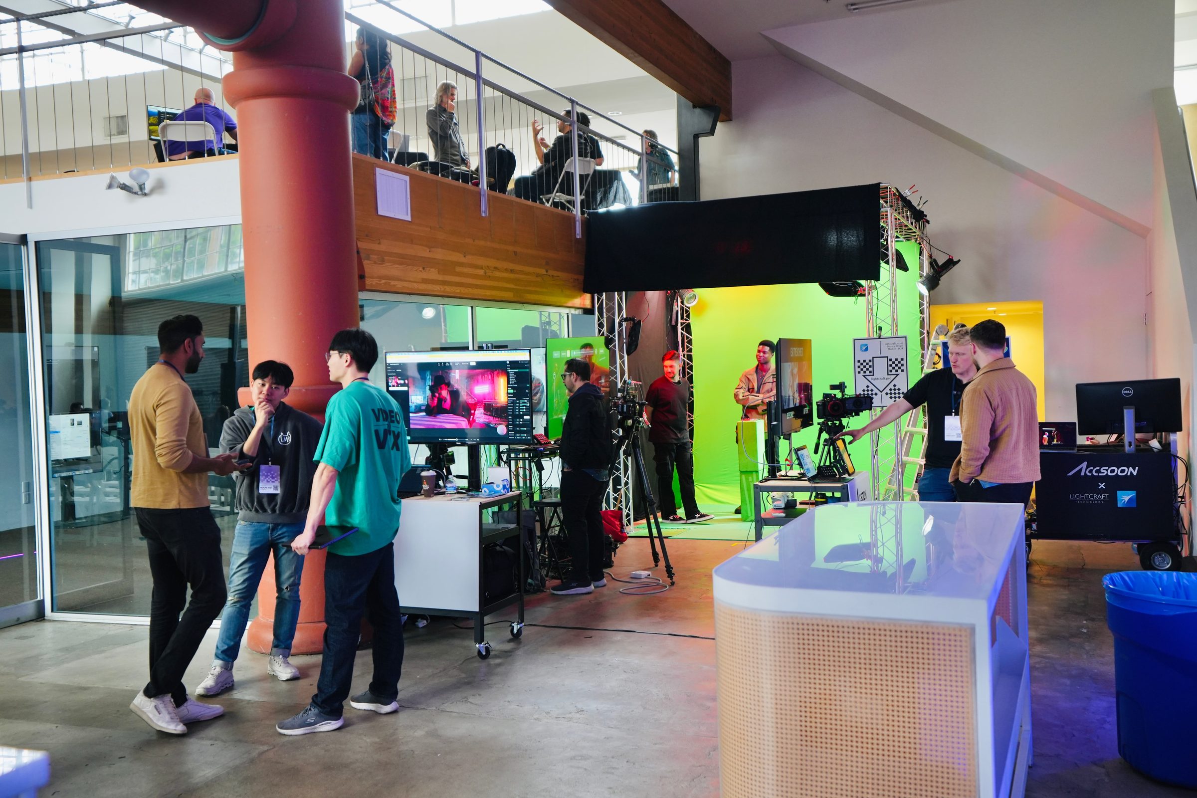 Attendees walk through a lab demo with a green screen, cameras, and a glowing virtual set.