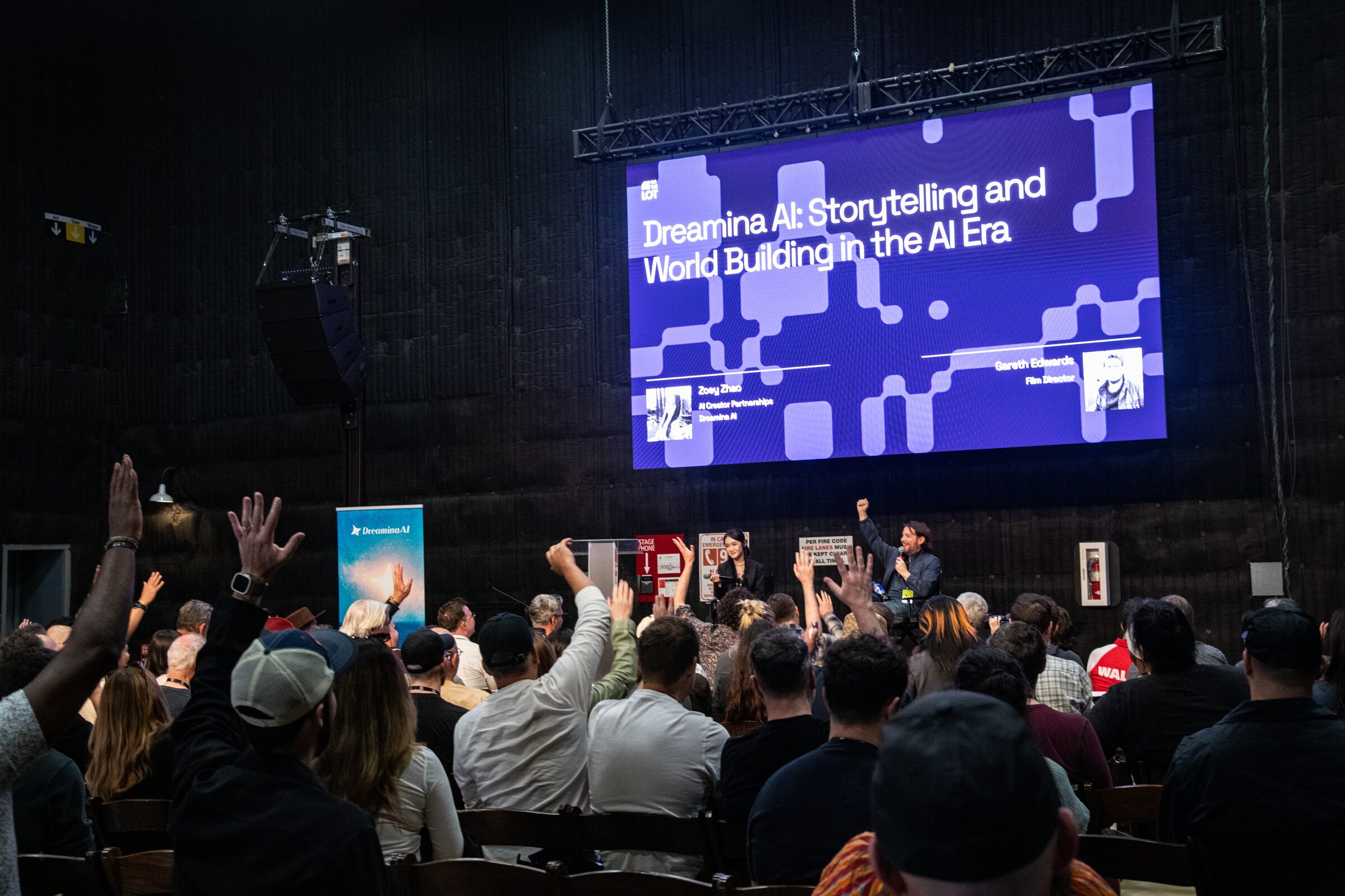 Audience members raise their hands toward the stage under a "Dreamina AI: Storytelling and World Building" slide.