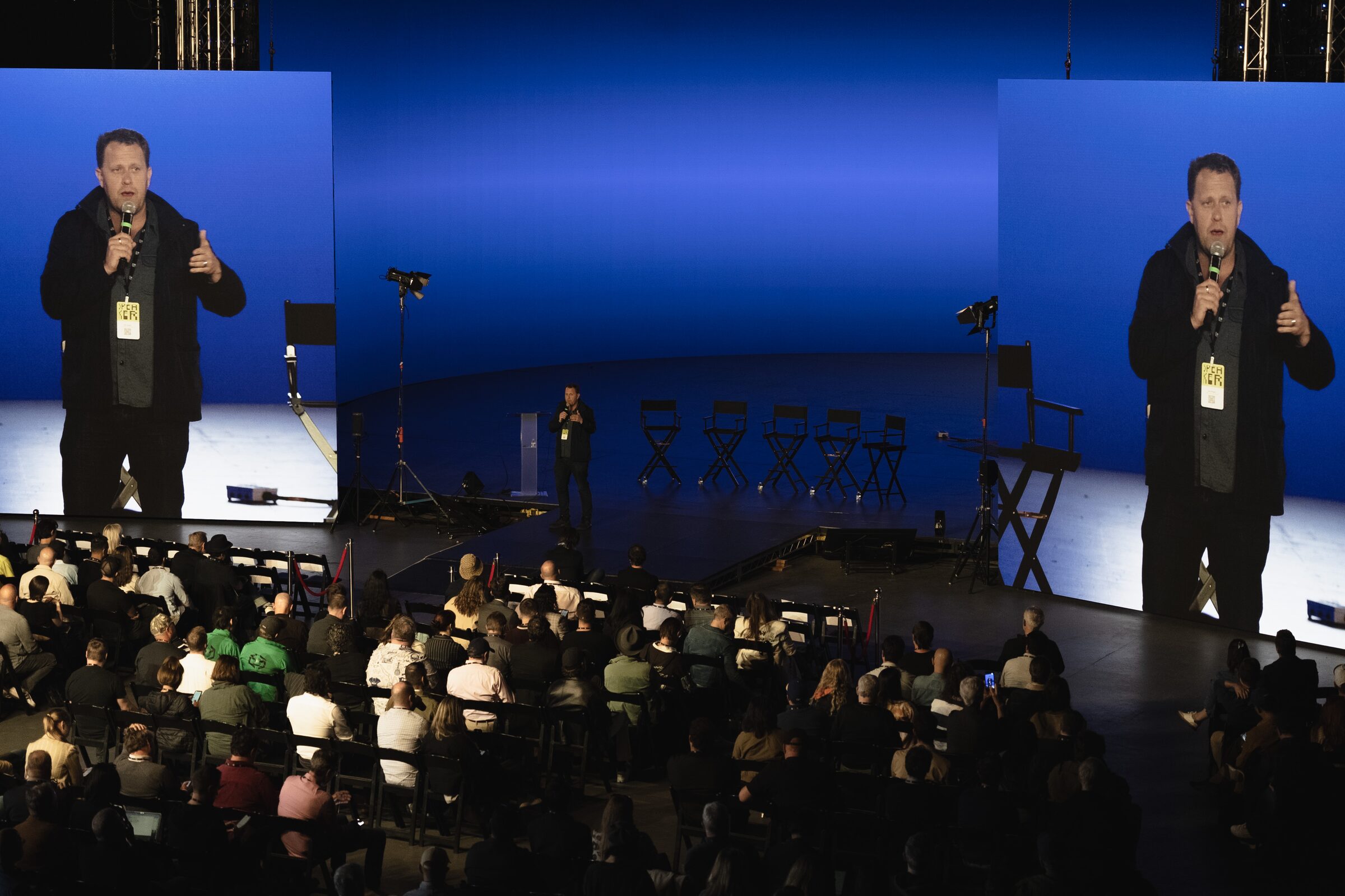 Jon Erwin, mic in hand and thumb up, fills two big screens flanking the blue stage before a full audience.